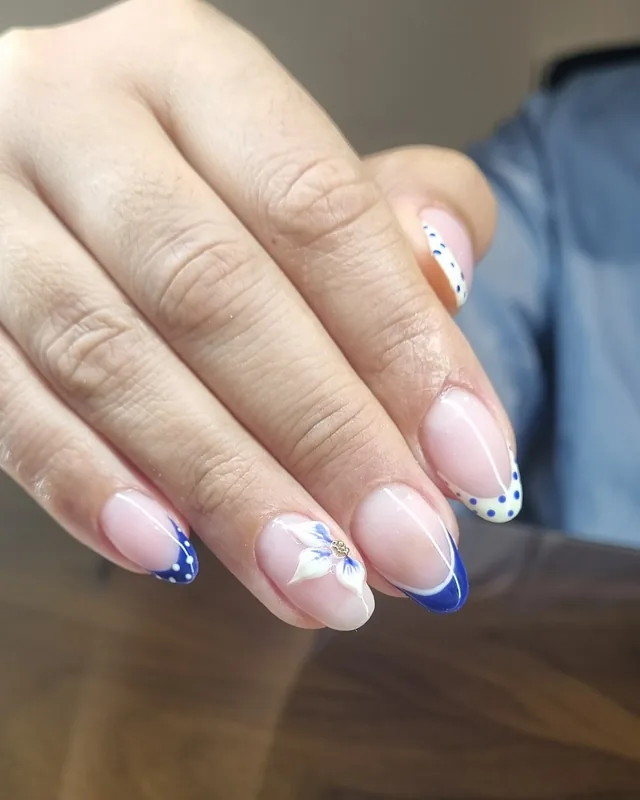 French manucure bleu marine avec une fleur blanche en relief